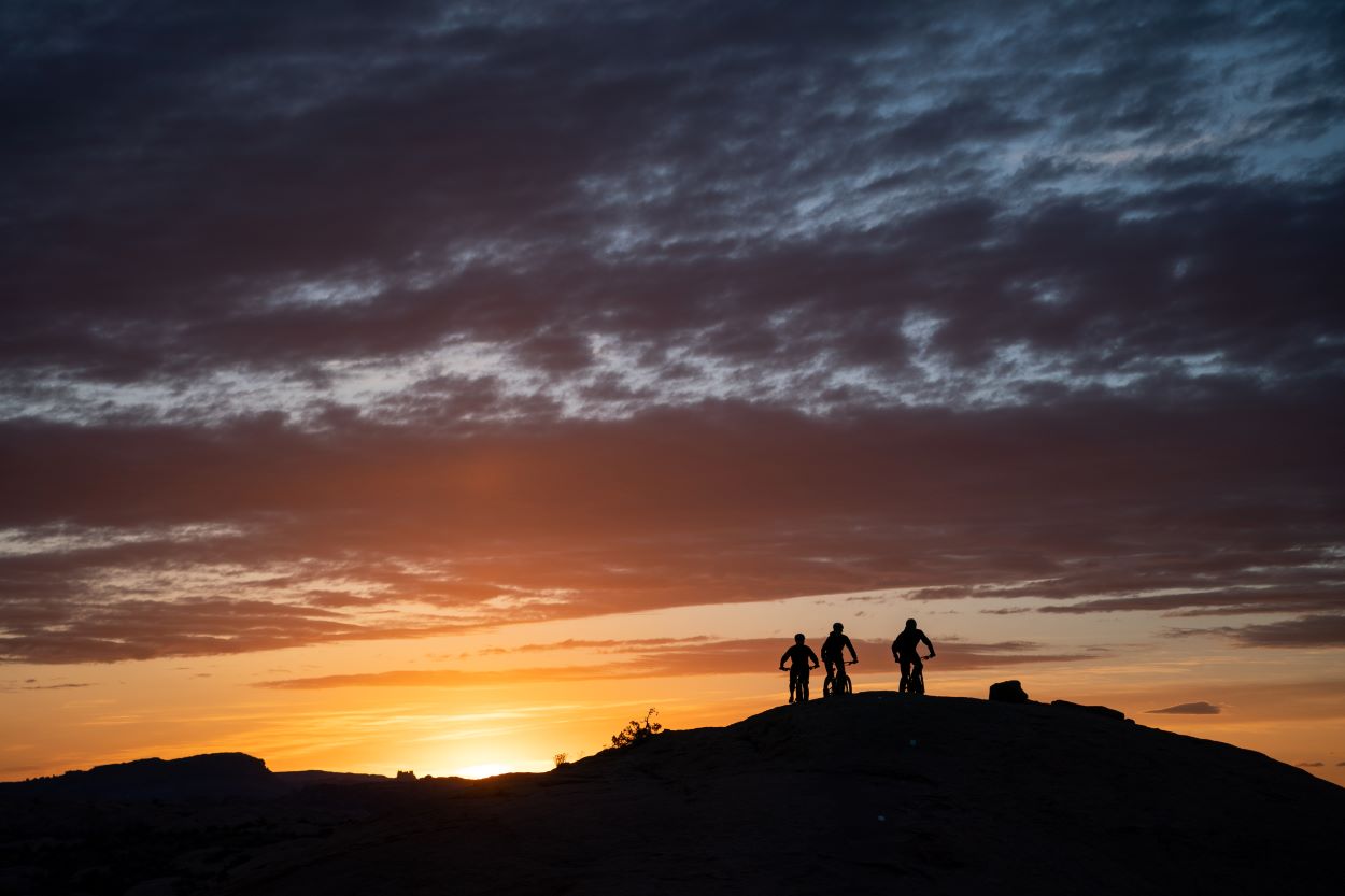 Mountain Bikers Riding Into Sunset in Moab
